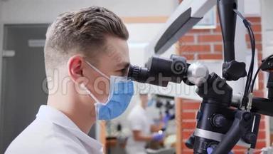 戴医用口罩的医务人员在实验室用<strong>光学显微镜</strong>检查
